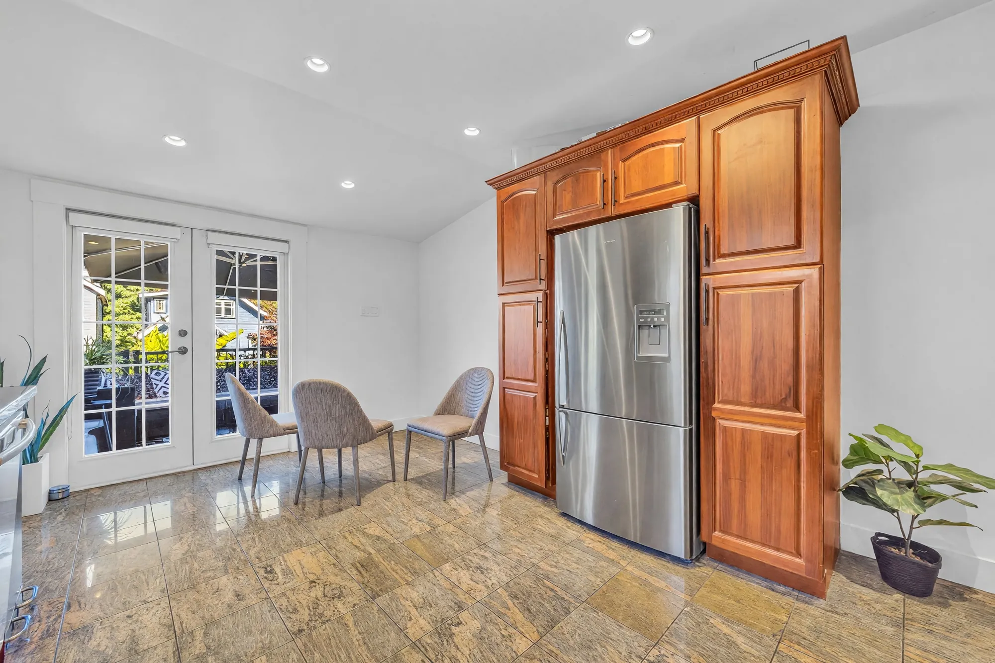 The breakfast area: French doors to the balcony, chairs on the tile floor, the refrigerator in its cherry surround