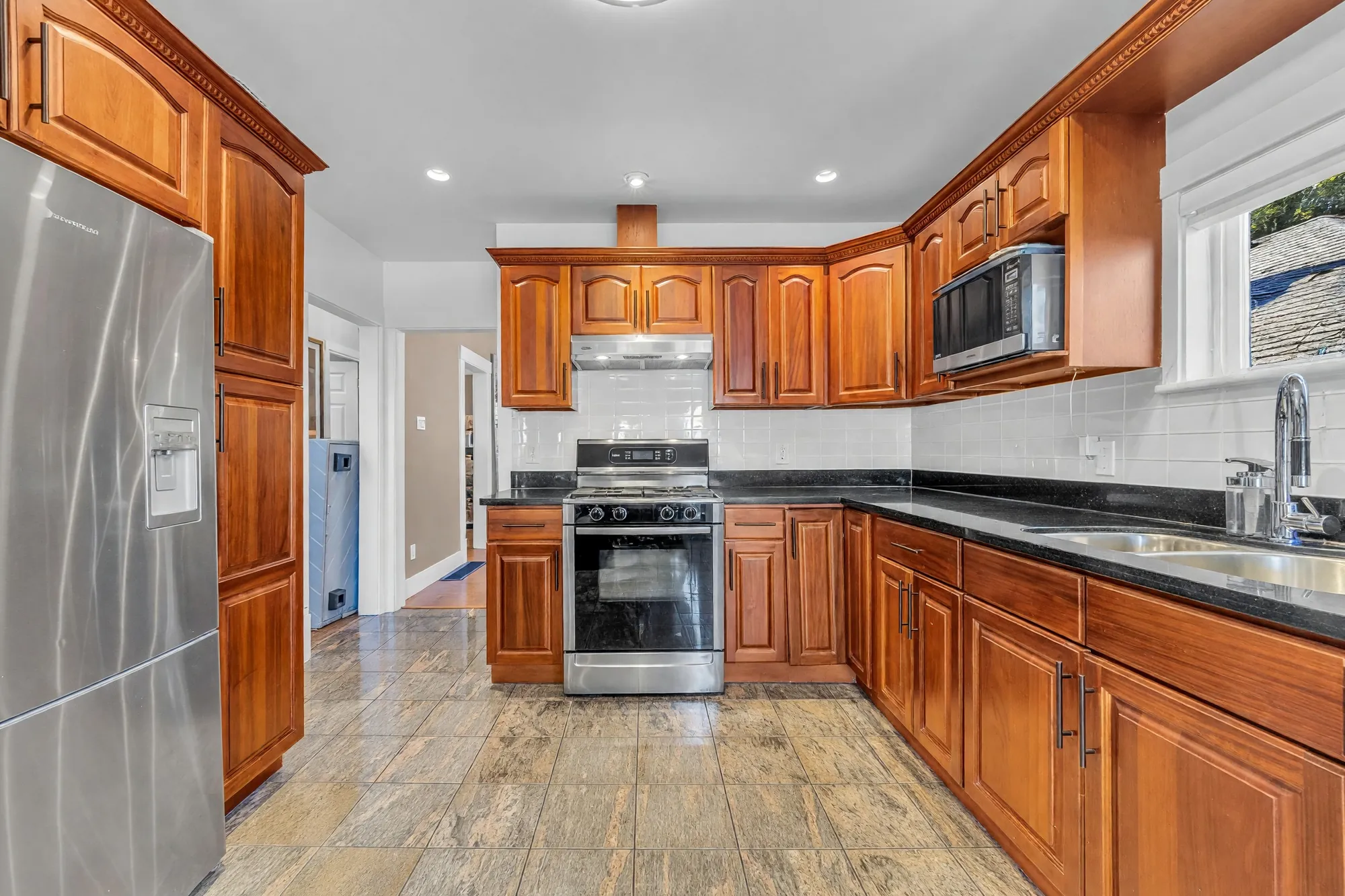 The kitchen from the refrigerator: the range, the window, the hall to the bedrooms on the left